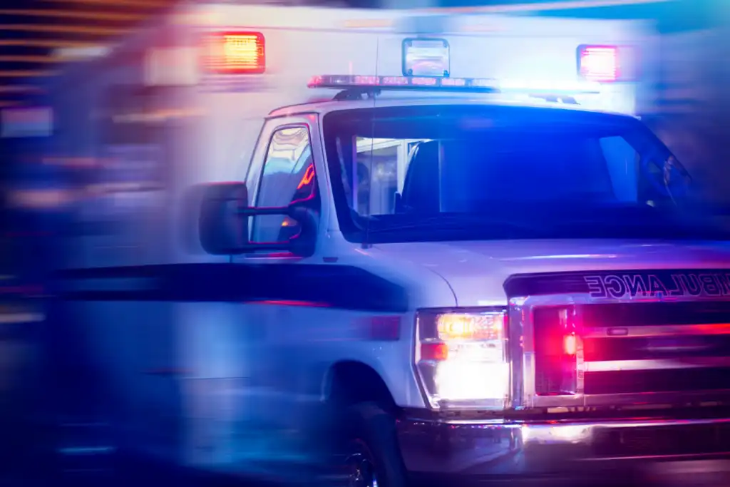 ambulance with lights on speeding down a street